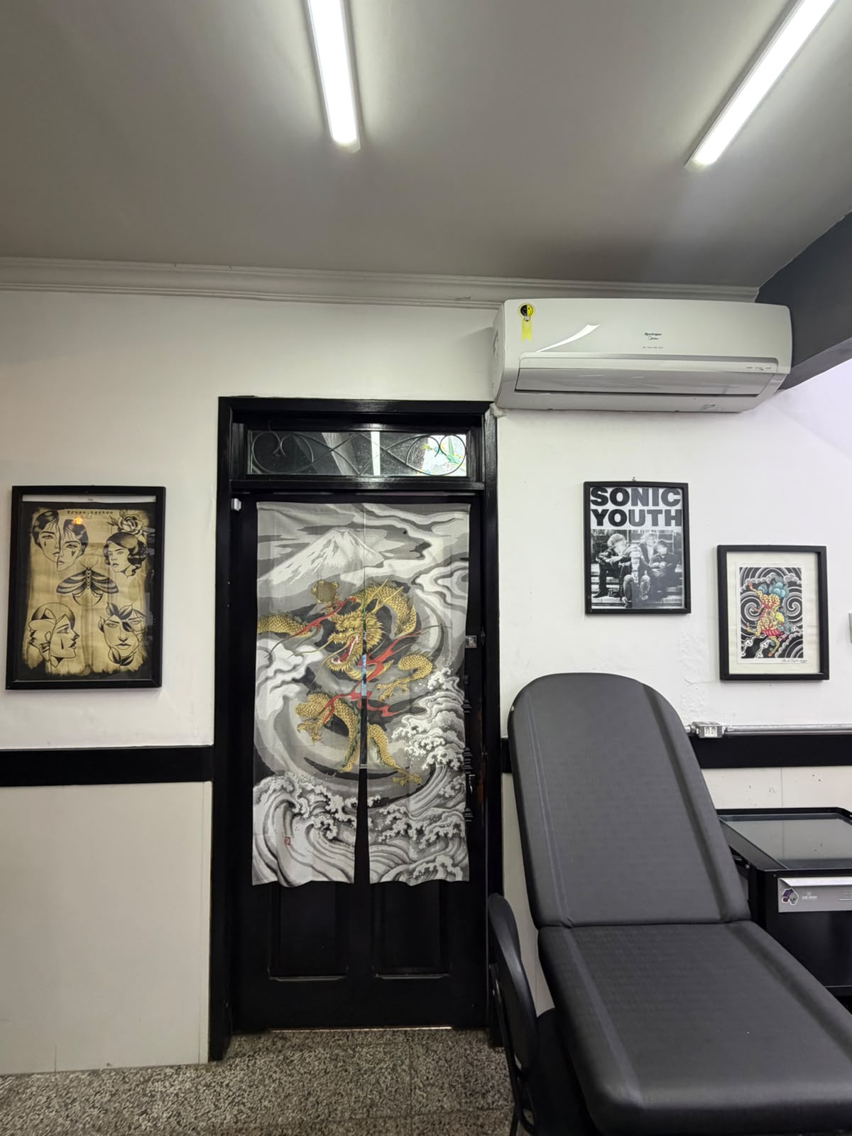 Entrada com noren de dragão e quadros