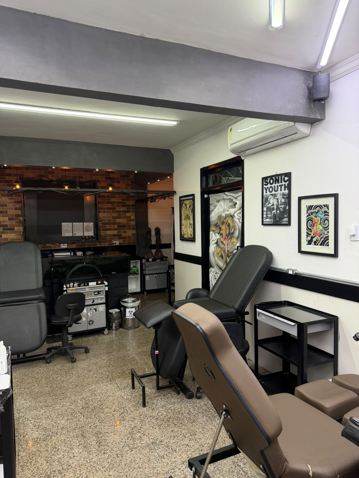 Ambiente principal com macas e estações de tatuagem